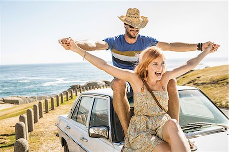 road, south africa - Mid adult couple with open arms on top of car on coast road, Cape Town, South Africa Stock Photo - Premium Royalty-Free, Code: 649-08543964