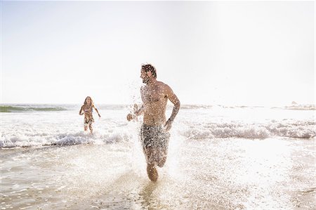 simsearch:649-07585546,k - Mid adult couple wearing swimming shorts running in sea, Cape Town, South Africa Stock Photo - Premium Royalty-Free, Code: 649-08543994