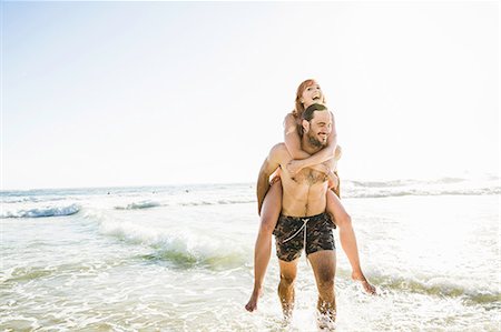 simsearch:649-07585546,k - Man wearing swimming shorts giving girlfriend piggyback in sea, Cape Town, South Africa Stock Photo - Premium Royalty-Free, Code: 649-08543996