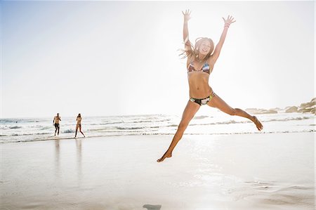 simsearch:649-07585546,k - Mid adult woman wearing bikini jumping mid air at beach, Cape Town, South Africa Stock Photo - Premium Royalty-Free, Code: 649-08543991