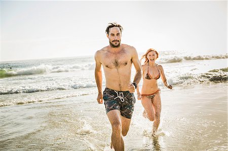 simsearch:649-07585546,k - Mid adult couple wearing bikini and swimming shorts running in sea, Cape Town, South Africa Stock Photo - Premium Royalty-Free, Code: 649-08543992