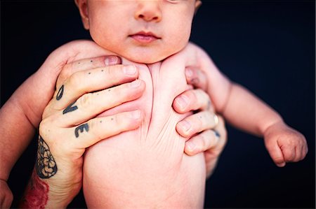 studio father son portraits - Father with tattooed hands holding baby boy Stock Photo - Premium Royalty-Free, Code: 649-08564267
