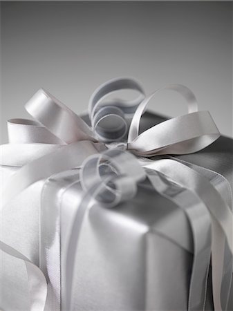 Still life with parcel wrapped in silver paper and ribbons Stock Photo - Premium Royalty-Free, Code: 649-08565435