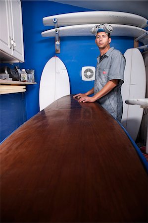 Portrait of a mid adult man and surfboard in his workshop Stock Photo - Premium Royalty-Free, Code: 649-08565638