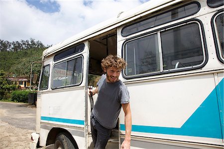 Smiling man leaning out bus door Stock Photo - Premium Royalty-Free, Code: 649-08561023