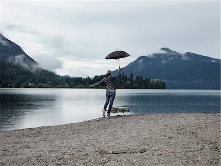 simsearch:649-08086253,k - Woman carrying umbrella by still lake Stock Photo - Premium Royalty-Free, Code: 649-08561219