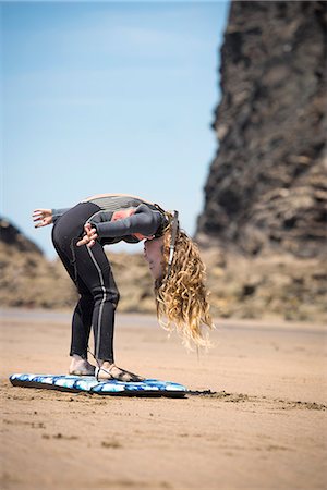 simsearch:649-06352471,k - Girl in wetsuit playing with surfboard Stock Photo - Premium Royalty-Free, Code: 649-08561278
