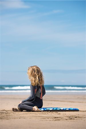 simsearch:649-06533379,k - Girl in wetsuit sitting on surfboard Photographie de stock - Premium Libres de Droits, Code: 649-08561279