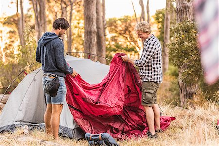 Two men concentrating on putting up tent in forest, Deer Park, Cape Town, South Africa Stock Photo - Premium Royalty-Free, Code: 649-08576275