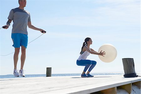 skipping - Couple on pier using skipping rope and exercise ball Stock Photo - Premium Royalty-Free, Code: 649-08576730