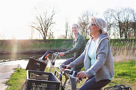 Side view of women cycling bicycles by river Stock Photo - Premium Royalty-Free, Code: 649-08576863