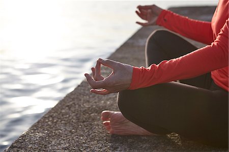 simsearch:649-07760822,k - Mature woman sitting beside water, in yoga position, low section Stock Photo - Premium Royalty-Free, Code: 649-08577001