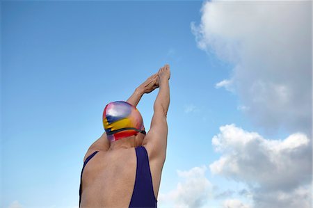 Mature woman, wearing swimming costume, arms raised, preparing to dive, rear view Stock Photo - Premium Royalty-Free, Code: 649-08577012