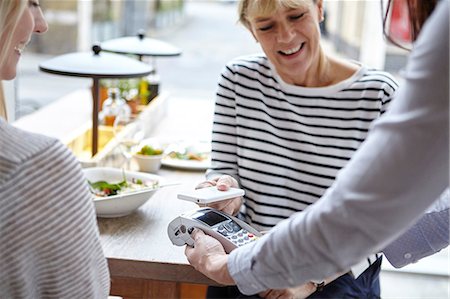 simsearch:6108-06907863,k - Woman using smartphone contactless payment at restaurant table, London, UK Stock Photo - Premium Royalty-Free, Code: 649-08577206