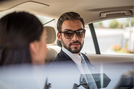 Young businessman and woman talking in car backseat, Dubai, United Arab Emirates Foto de stock - Sin royalties Premium, Código: 649-08577507