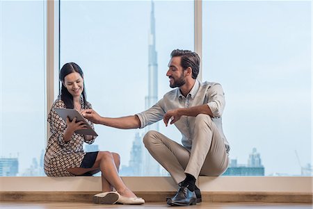 Businesswoman and man sitting at window, Dubai, United Arab Emirates Stock Photo - Premium Royalty-Free, Code: 649-08577548