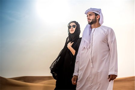 Couple wearing traditional middle eastern clothes in desert, Dubai, United Arab Emirates Foto de stock - Sin royalties Premium, Código: 649-08577595