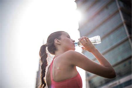 Woman training, drinking bottled water in park, Dubai, United Arab Emirates Stock Photo - Premium Royalty-Free, Code: 649-08577633