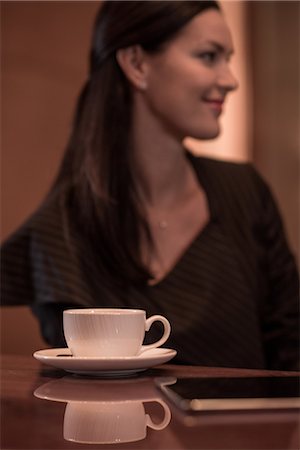 Businesswoman sitting at hotel bar with coffee and  digital tablet Stock Photo - Premium Royalty-Free, Code: 649-08577655