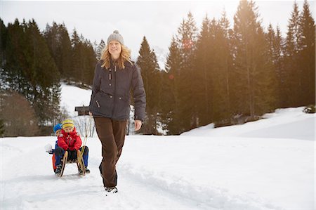 Woman pulling sons on toboggan in snow covered landscape, Elmau, Bavaria, Germany Stock Photo - Premium Royalty-Free, Code: 649-08577749