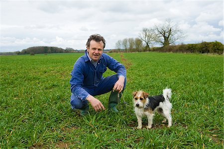 simsearch:649-07560533,k - Portrait of farmer crouching in field with dog Stock Photo - Premium Royalty-Free, Code: 649-08577792
