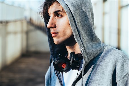 Portrait of man wearing hooded top and headphones looking away Stock Photo - Premium Royalty-Free, Code: 649-08577885