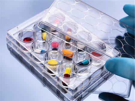 painkiller - Pharmaceutical research, hand removing lid from variety of medical drugs in a multi well tray for laboratory testing Photographie de stock - Premium Libres de Droits, Code: 649-08660621