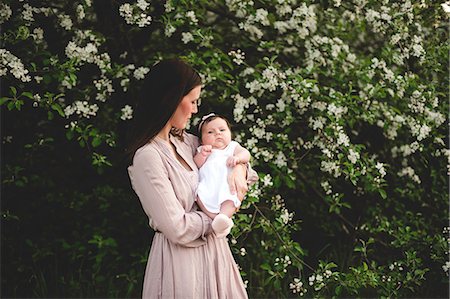 Portrait of baby girl in mothers arms by garden apple blossom Foto de stock - Sin royalties Premium, Código: 649-08661151