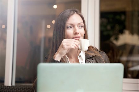 Businesswoman with laptop drinking espresso at sidewalk cafe Stock Photo - Premium Royalty-Free, Code: 649-08702415