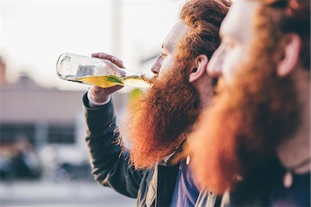 simsearch:649-08702620,k - Profile of young male hipster twins with red hair and beards drinking bottled beer Stock Photo - Premium Royalty-Free, Code: 649-08702668