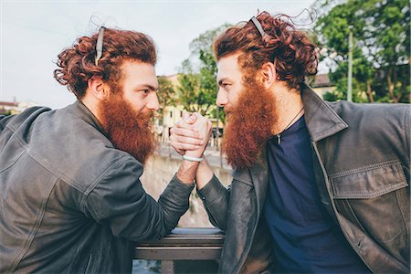 simsearch:649-08702620,k - Young male hipster twins with red hair and beards arm wrestling on bridge Stock Photo - Premium Royalty-Free, Code: 649-08702671