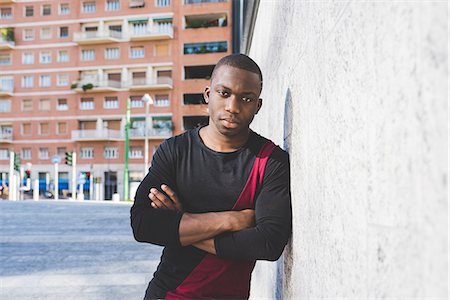 Portrait of young man leaning against wall, arms folded, pensive expression Photographie de stock - Premium Libres de Droits, Code: 649-08703079