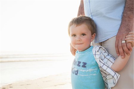 simsearch:614-06623416,k - Boy on beach holding fathers hands looking at camera smiling Stock Photo - Premium Royalty-Free, Code: 649-08703180