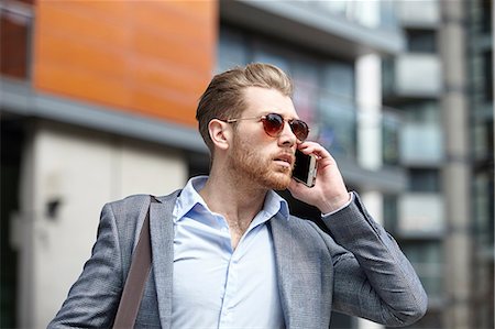 simsearch:649-07560129,k - Young businessman wearing sunglasses talking on smartphone outside office, London, UK Foto de stock - Sin royalties Premium, Código: 649-08714631