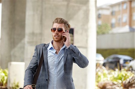 simsearch:649-07560129,k - Young businessman wearing sunglasses talking on smartphone outside office, London, UK Foto de stock - Sin royalties Premium, Código: 649-08714632