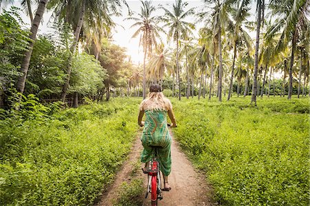simsearch:649-08900720,k - Rear view of young woman cycling in palm tree forest, Gili Meno, Lombok, Indonesia Stock Photo - Premium Royalty-Free, Code: 649-08745116