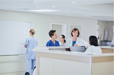 Female doctor having discussion with nurses at nurses station in hospital Foto de stock - Sin royalties Premium, Código: 649-08745382