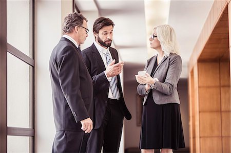 simsearch:649-07520071,k - Businessmen and woman having discussions in office corridor Stock Photo - Premium Royalty-Free, Code: 649-08745588