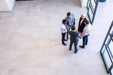simsearch:649-06040639,k - High angle view of businesswoman and men having discussion in office atrium Stock Photo - Premium Royalty-Free, Code: 649-08765794