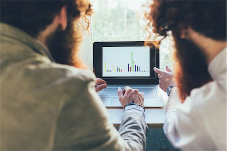 simsearch:649-08702620,k - Over shoulder view of male twins working on laptop in office Stock Photo - Premium Royalty-Free, Code: 649-08765935