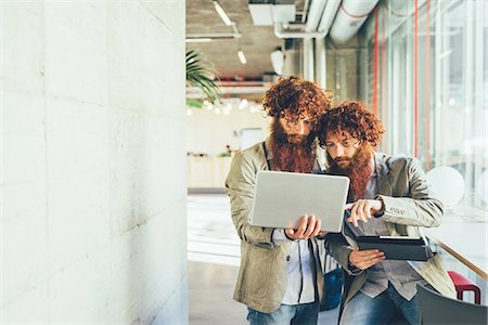 simsearch:649-08702620,k - Male adult hipster twins pointing at laptop in office Stock Photo - Premium Royalty-Free, Code: 649-08765943