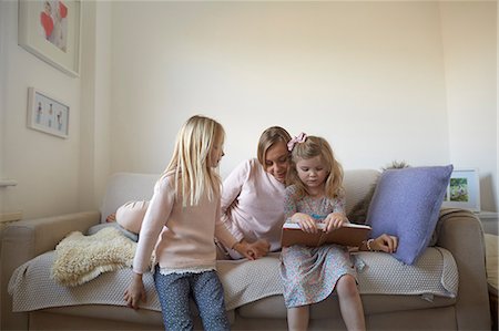 simsearch:649-07805043,k - Mid adult woman and daughters reading storybook on sofa Stock Photo - Premium Royalty-Free, Code: 649-08766244