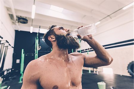 dehydrated - Exhausted male cross trainer drinking water in gym Foto de stock - Sin royalties Premium, Código: 649-08766479