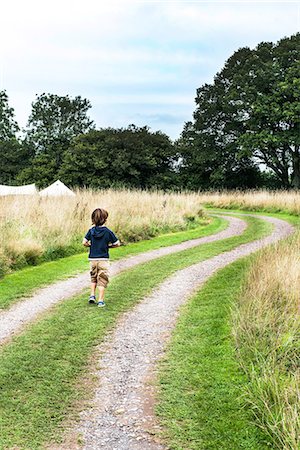 simsearch:649-06845253,k - Rear view of boy walking on dirt track Stock Photo - Premium Royalty-Free, Code: 649-08824236