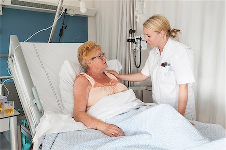 Nurse tending to patient in hospital bed Stock Photo - Premium Royalty-Free, Code: 649-08824254