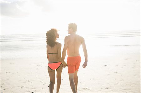 simsearch:649-07585546,k - Rear view of young couple in swimwear strolling on sunlit beach, Cape Town, Western Cape, South Africa Stock Photo - Premium Royalty-Free, Code: 649-08824624