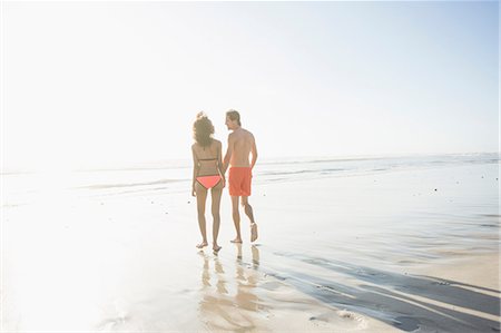 simsearch:649-07585546,k - Rear view of young couple in swimwear strolling on sunlit beach, Cape Town, Western Cape, South Africa Stock Photo - Premium Royalty-Free, Code: 649-08824625