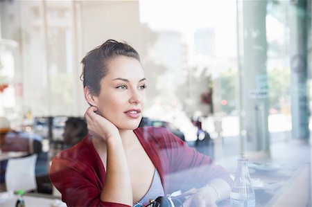 simsearch:614-06897927,k - Young woman sitting in cafée, looking out of window Foto de stock - Sin royalties Premium, Código: 649-08824733