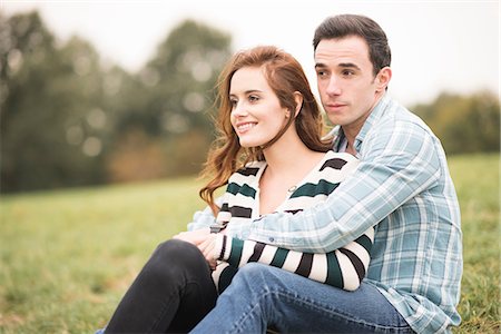 simsearch:649-08239088,k - Couple sitting in field hugging looking away Stock Photo - Premium Royalty-Free, Code: 649-08825055