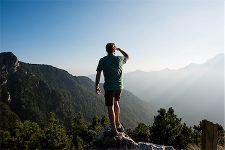 silhouette of man standing in a mountain top - Rear view of man standing on mountain peak looking away, Passo Maniva, Italy Stock Photo - Premium Royalty-Free, Code: 649-08823983